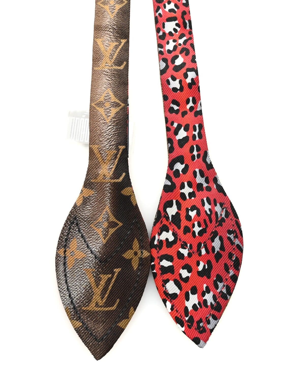 A Louis Vuitton monogram silk twilly beside a red leopard-print twilly